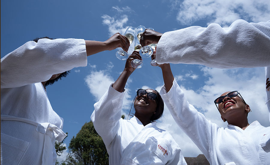 Bridal party in robes toasting drinks outdoors